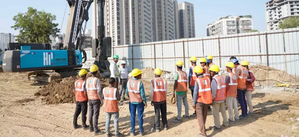 Two project managers/engineers in a conversation with workers on a construction site.