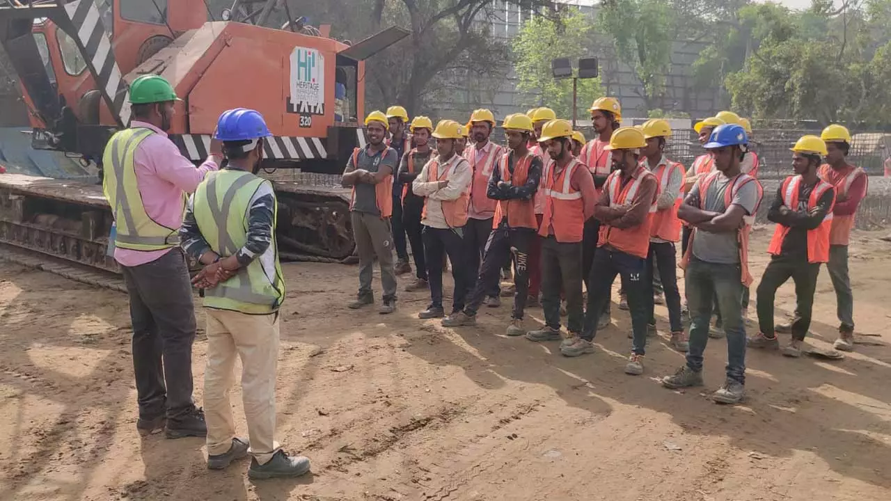 A safety supervisor on a construction site briefs a team of workers